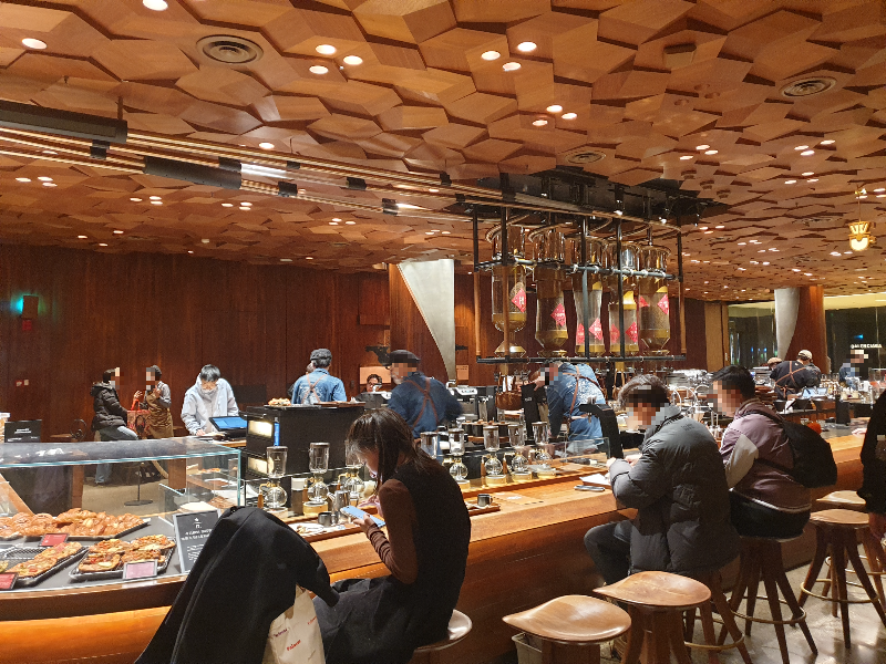 바테이블에 여러 손님들이 앉아 음료를 즐기고 있다.