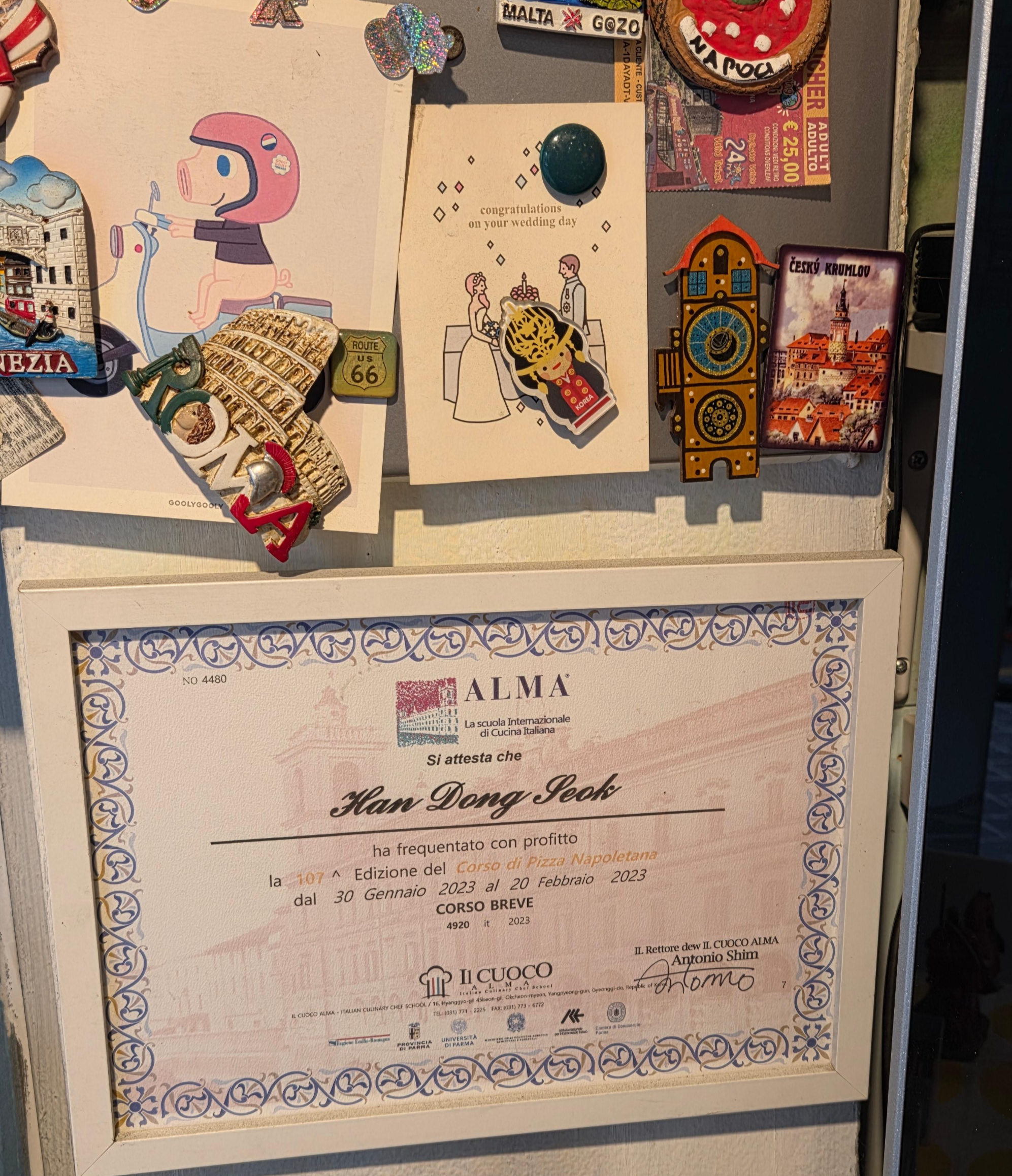 매장 벽에 걸린 이탈리아 ALMA 피자 아카데미 수료증과 엽서 장식