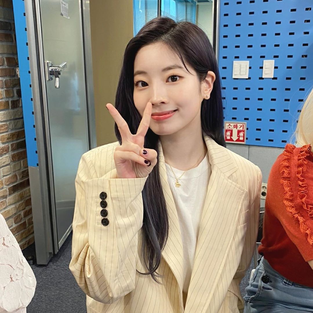 트와이스 다현이 방송 스튜디오에서 손가락으로 V자를 그리며 미소짓고 있는 사진