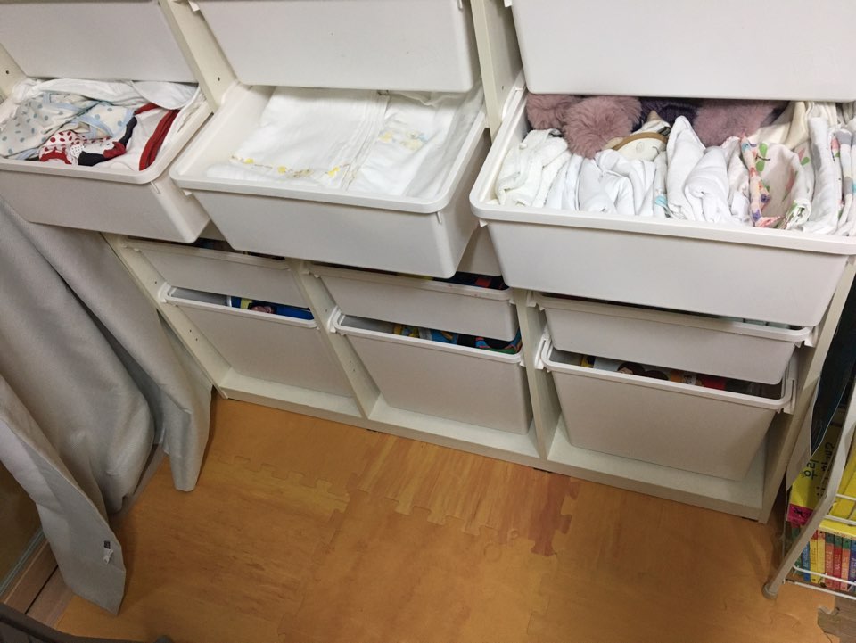 하얀색 한샘 샘키즈 수납장 안에 아이 옷과 가재수건, 천기저귀 등이 칸별로 정리되어 있는 모습