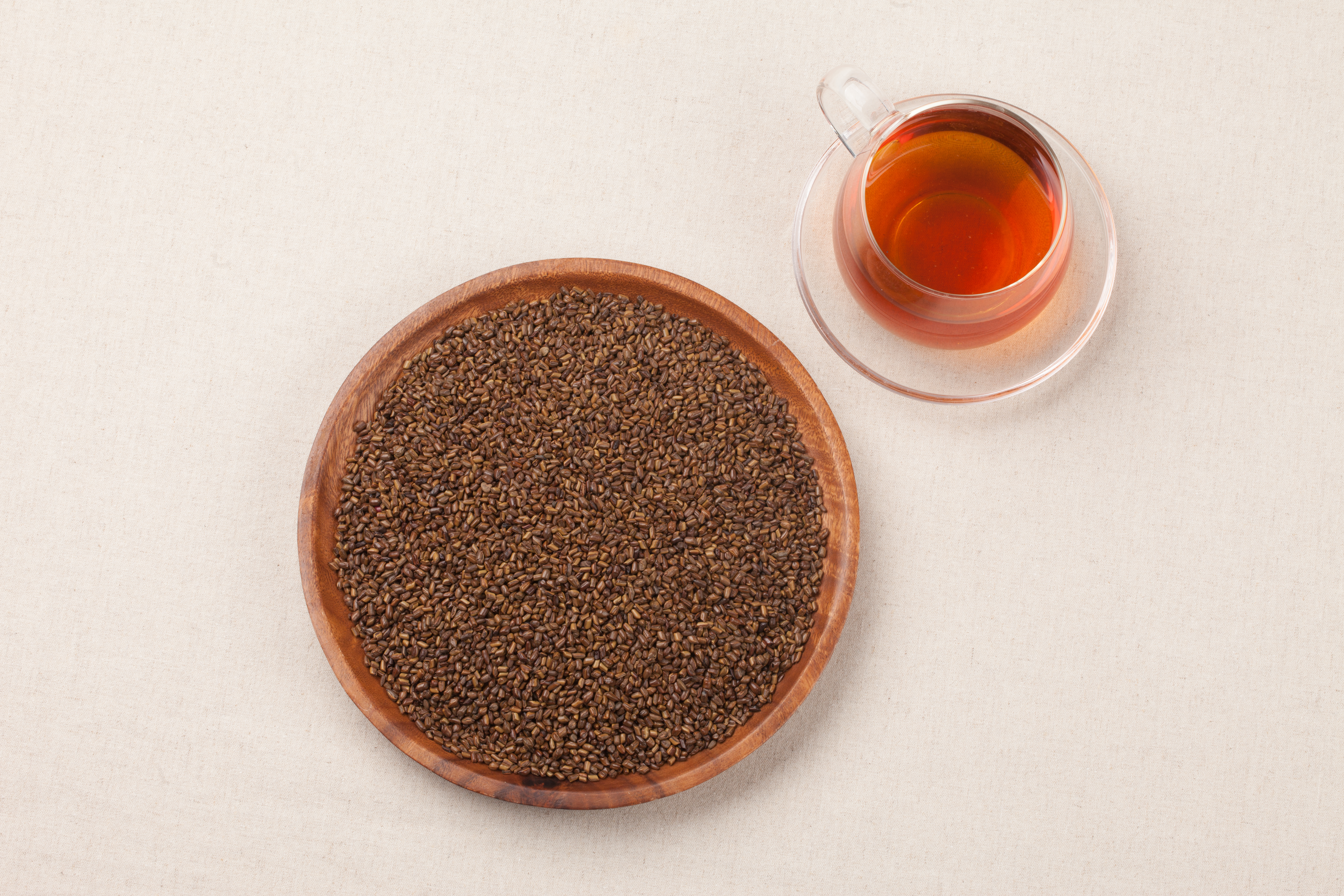 나무 그릇에 결명자를 가득 담아두었고, 오른쪽 위에 결명자차를 투명한 유리잔에 놓아 둔 사진