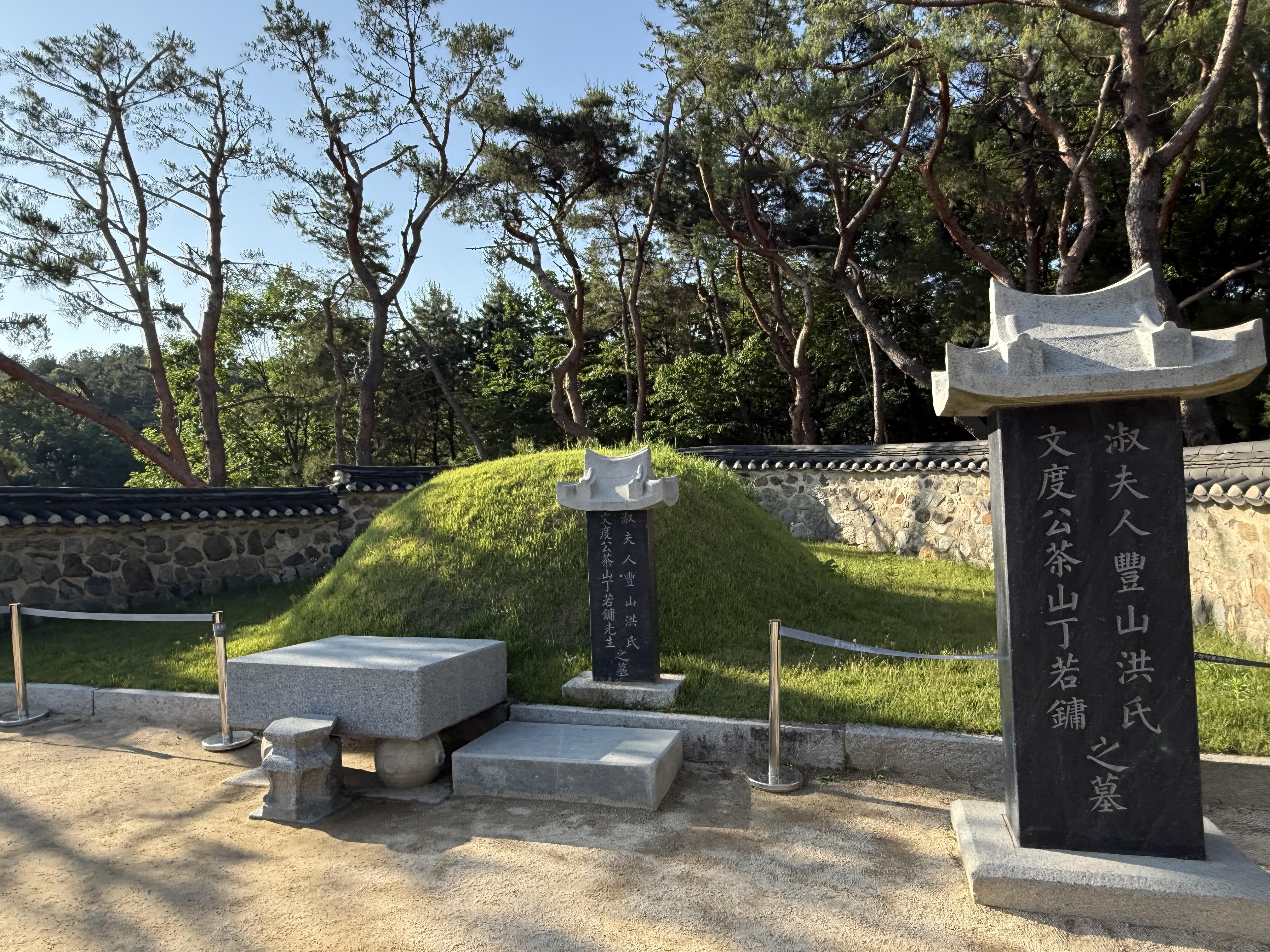 정약용 선생 묘소의 전경. 잔디로 덮인 봉분과 주변을 둘러싼 담장, 그리고 소나무들이 고즈넉한 분위기를 연출한다.