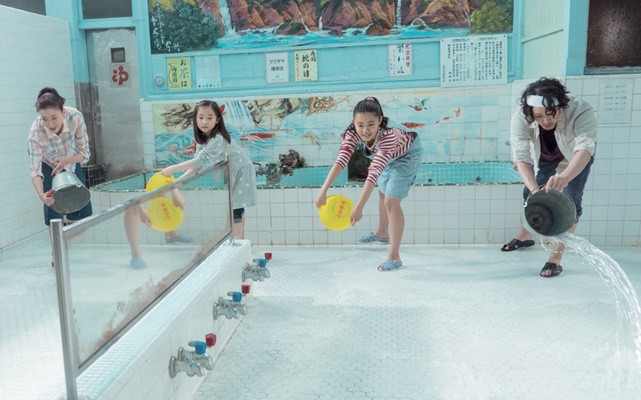 영화 행복 목욕탕에서 주인공 후타바와 가족들이 목욕탕 사치노유를 함께 청소하며 물을 뿌리는 생동감 넘치는 장면