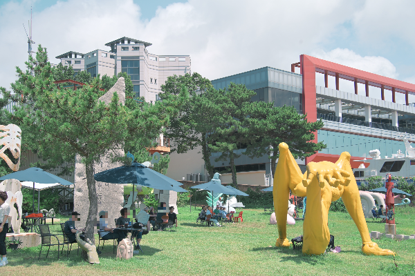 잔디밭 위에 조각 품과 파라솔들이 배치 되어 있다.