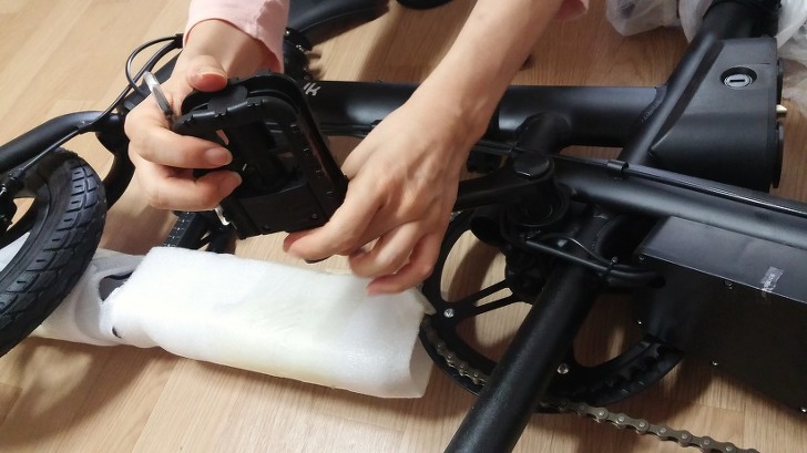 Assembling the Ideawalk electric bike by hand-installing the pedal