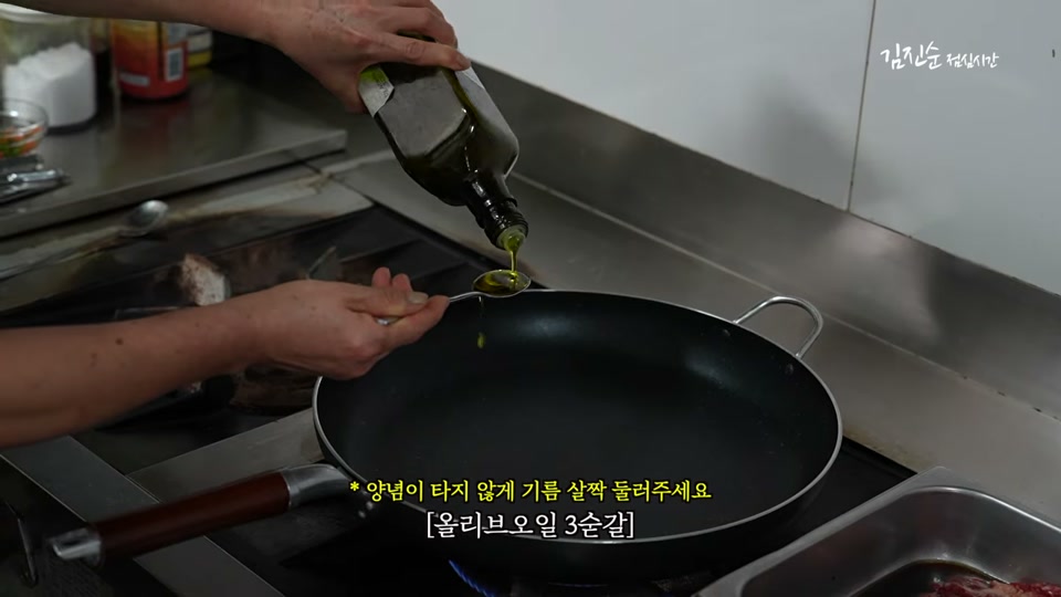 약불로 달군 팬에 올리브오일을 두르는 장면