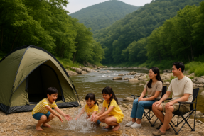 계곡물이 흐르는 곳에서 캠핑하고 있는 가족 모습