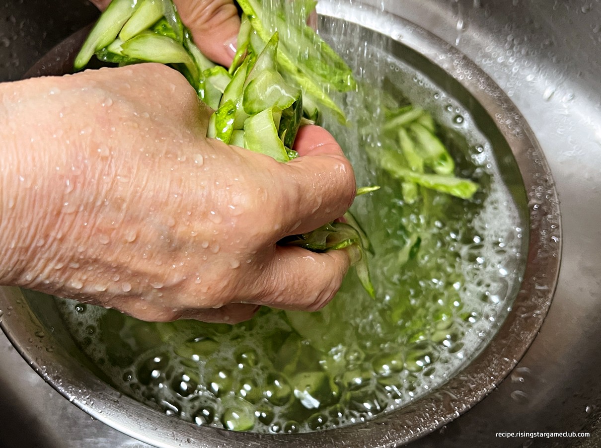 냉면 고명용 절인 오이를 흐르는 물에 헹구는 사진