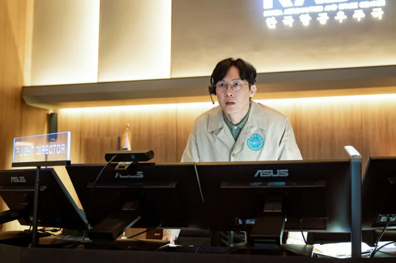 항공우주센터를 배경으로 이어폰을 꼽고 모니터를 바라보고 있는 영화 더 문의 정민규