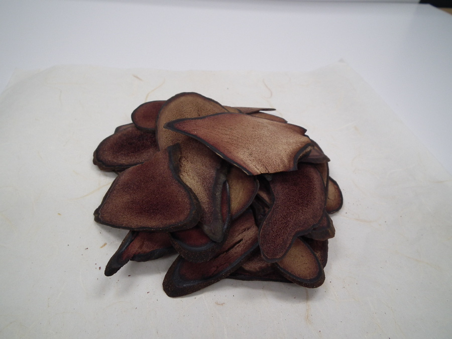 야생에서 자라고 있는 사슴의 뿔을 잘라서 편으로 얇게 썰어서 건조시킨 녹용을 하얀 바닥 위에 수북하게 쌓아두고 찍은 사진