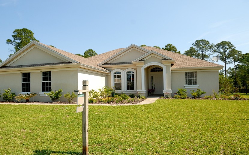 a single family home with lawn and a for sale sign.