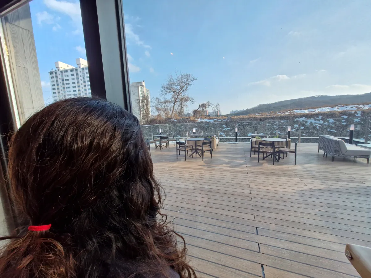 야외테이블-창밖을-바라보고-있는-여성