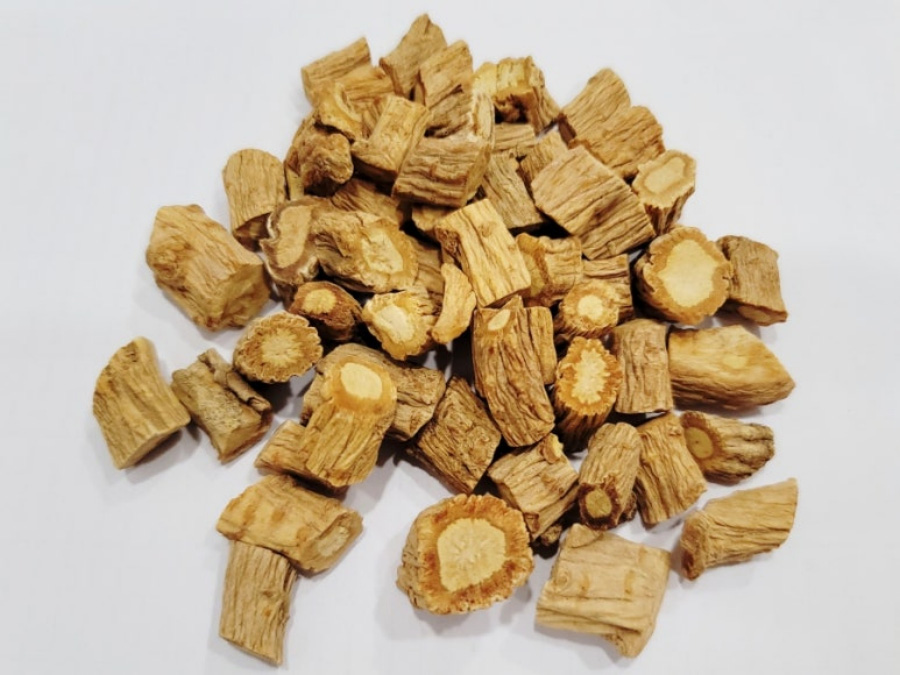 야생에서 채취를 한 방풍을 깨끗하게 세척하고 건조시킨 것을 편으로 절단을 한 것을 하얀 바닥 위에 수북하게 놓아두고 찍은 사진