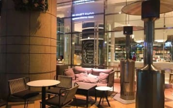 테이블과 의자가 가게 앞에 놓여져 있다.