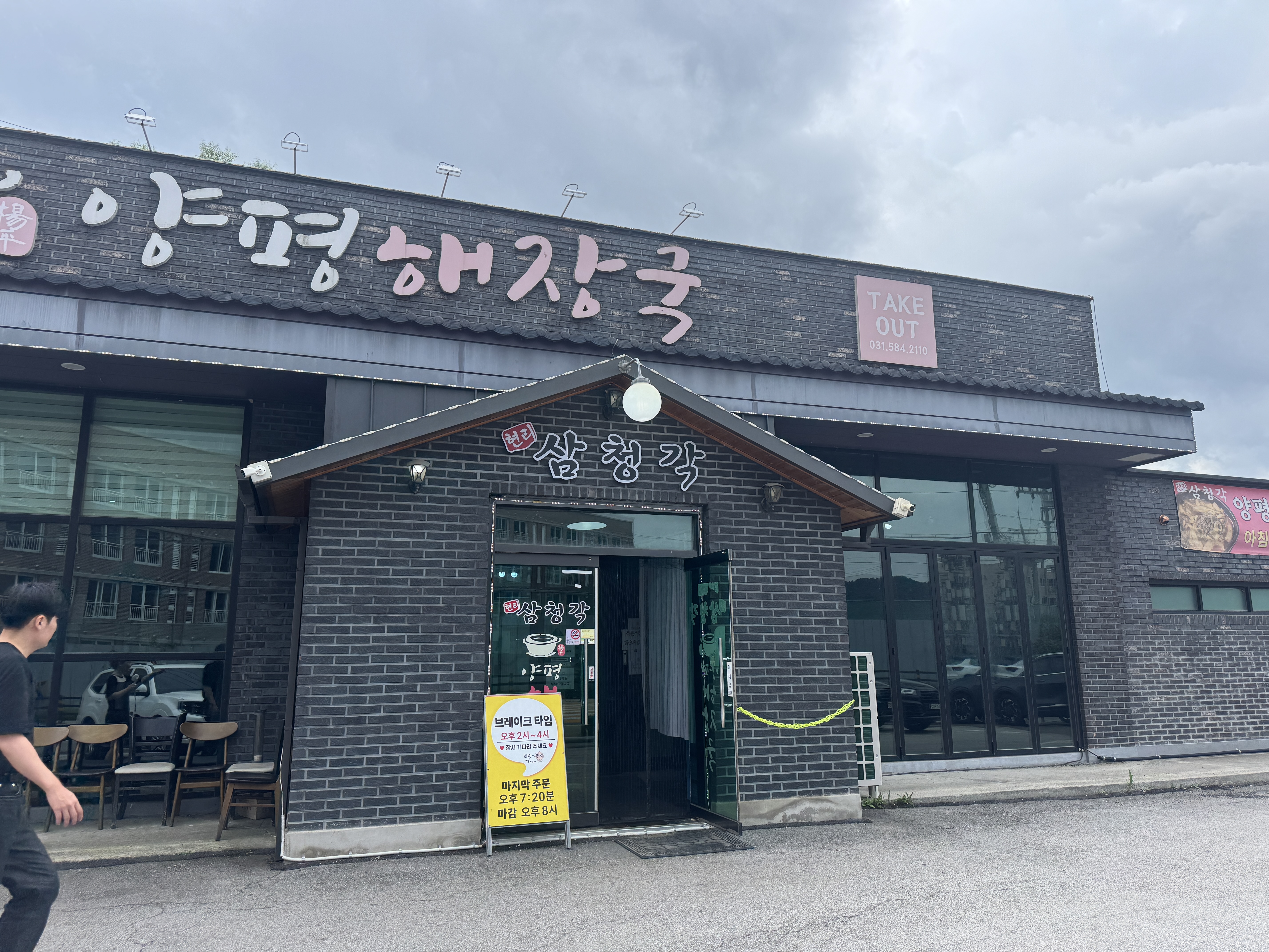 양평 해장국 본관 전경. 검은 벽돌 건물 외관에 간판이 크게 걸려 있고, 입구 앞에는 손님들이 드나드는 모습이 보인다.