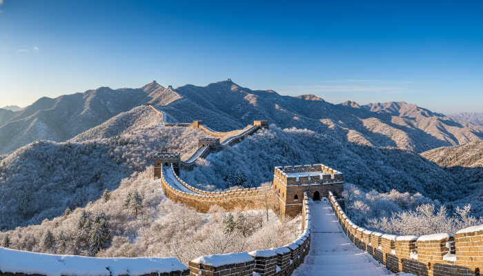 눈 덮인 산맥을 따라 끝없이 펼쳐진 웅장한 만리장성의 겨울 설경