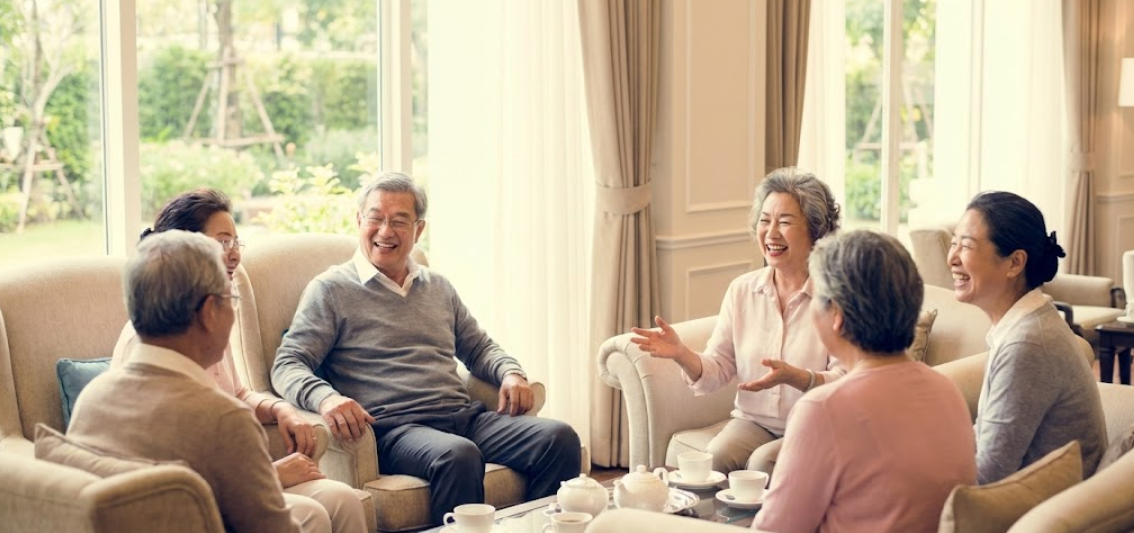 편안한 시설의 실버타운 휴게실에서 동료들과 대화하는 노인들