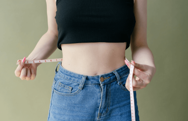 다이어트용 차 진짜 효과 있을까, 허리둘레를 측정하는 여성