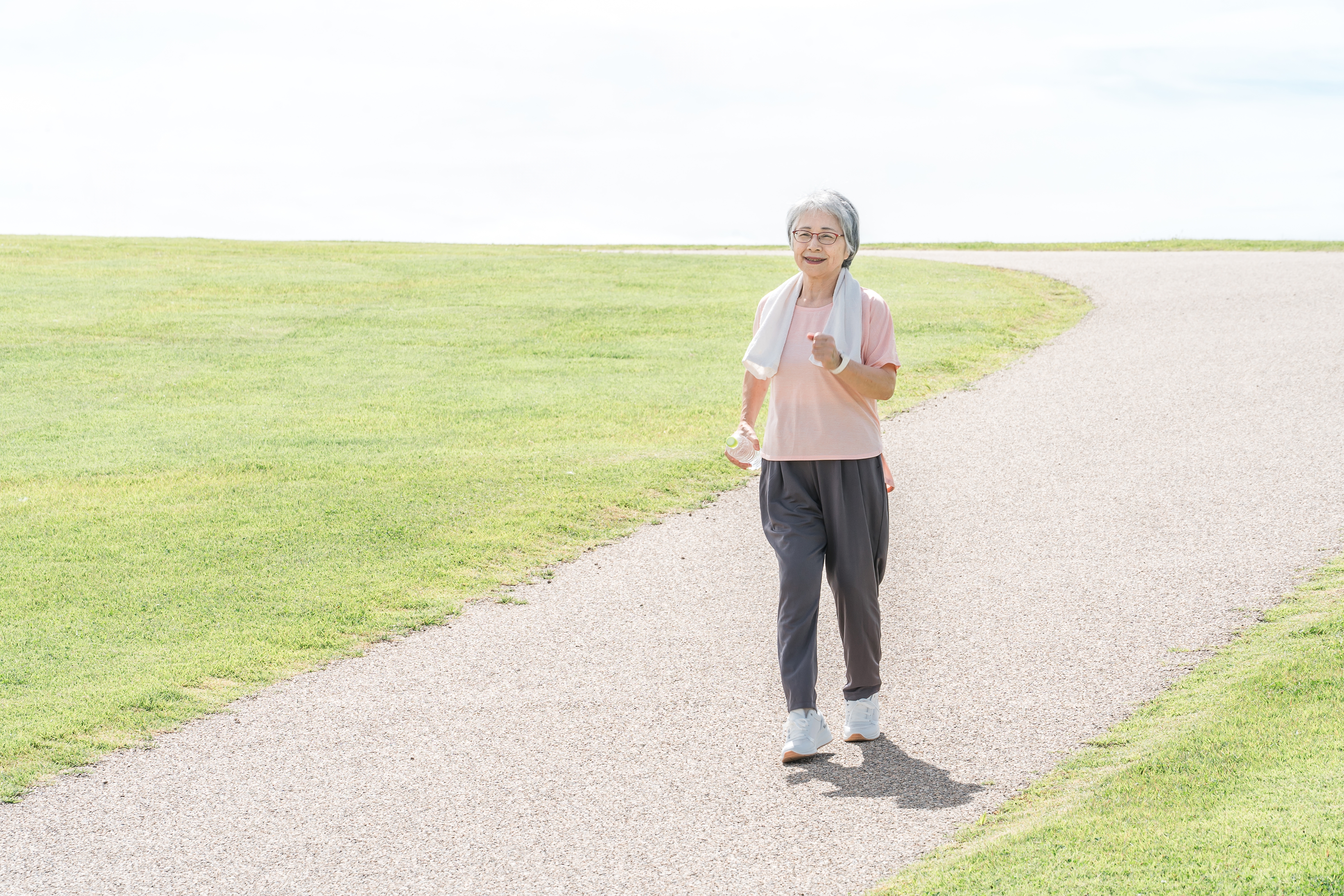 밝은 날씨에 평지 산책로를 걷는 중년 여성｜무릎 부담 없이 즐기는 건강한 걷기 다이어트