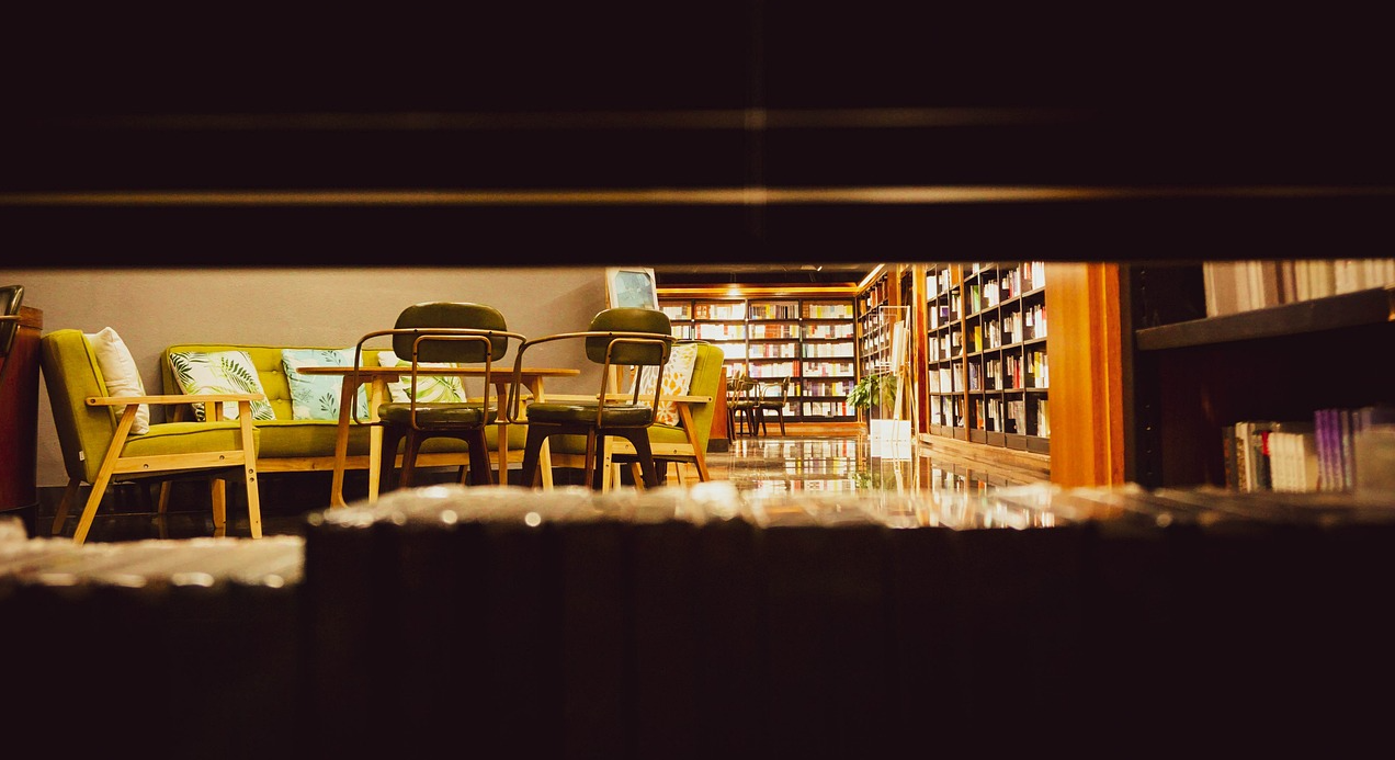 조용한 도서관 내부, 낮은 시선에서 바라본 책장과 테이블이 있는 공간