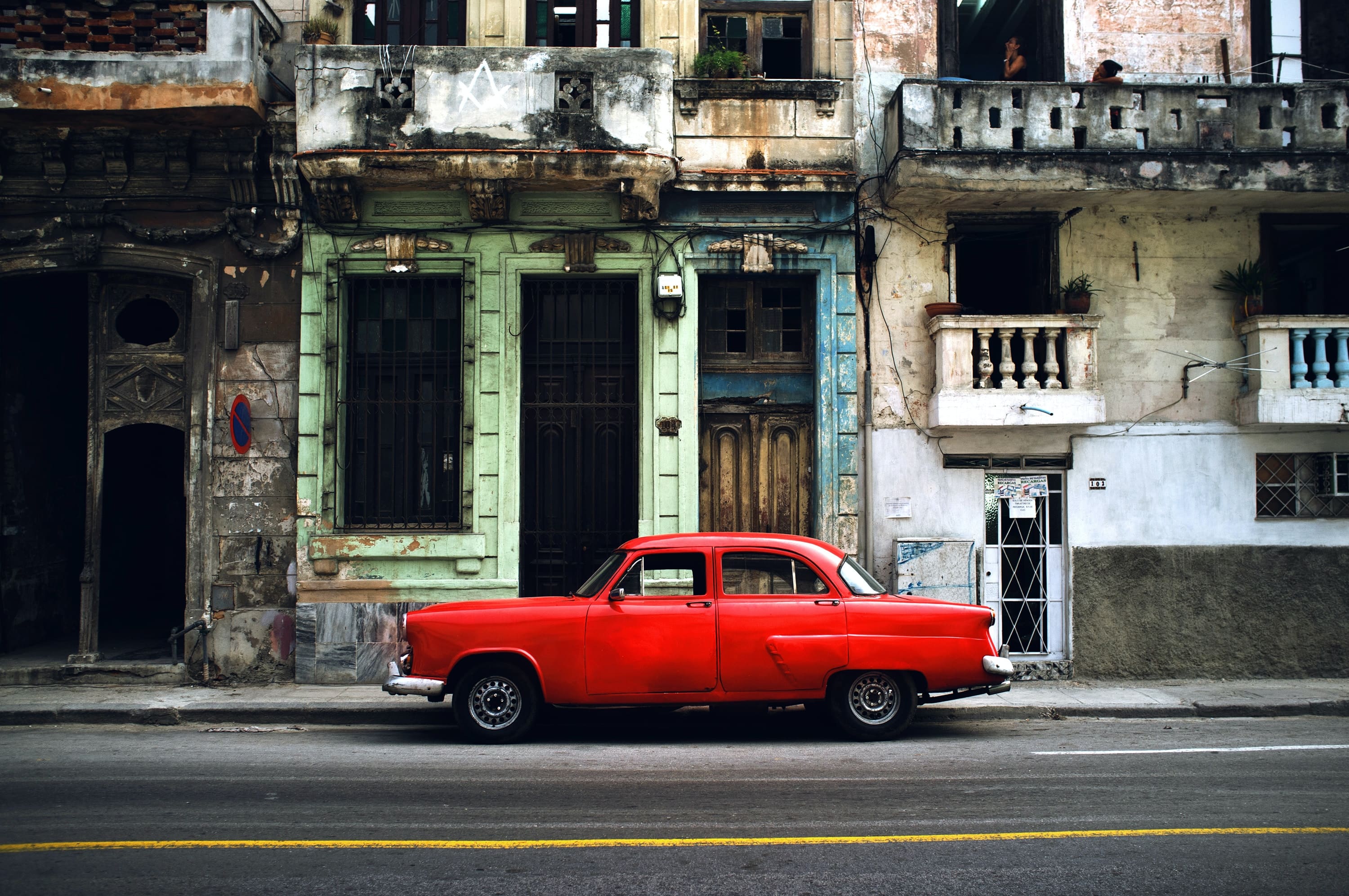 Red old car parked on the street
