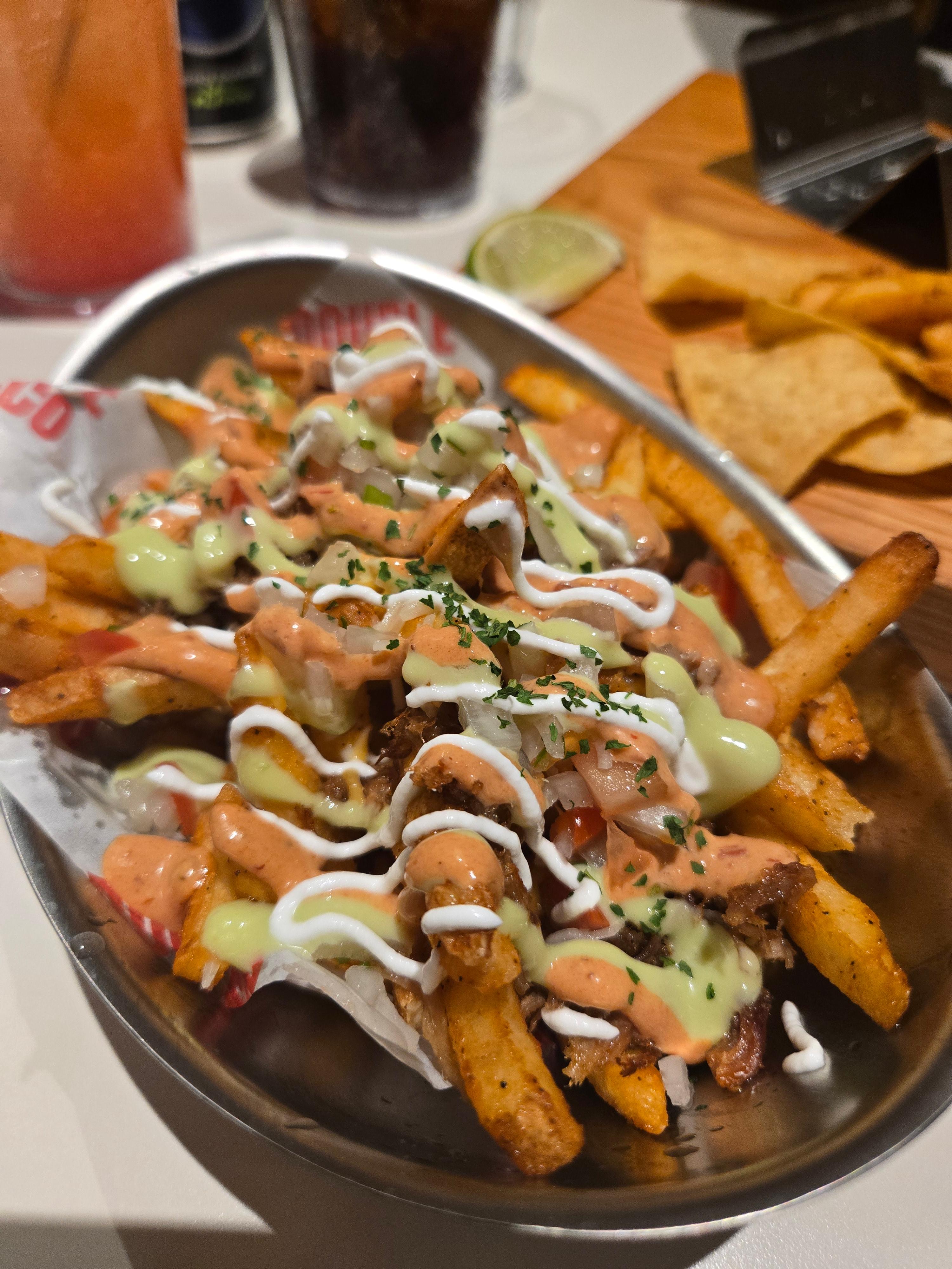 더블 타코 사이드 메뉴 중 감자튀김에 소스와 토핑이 올려져 있는 파타타