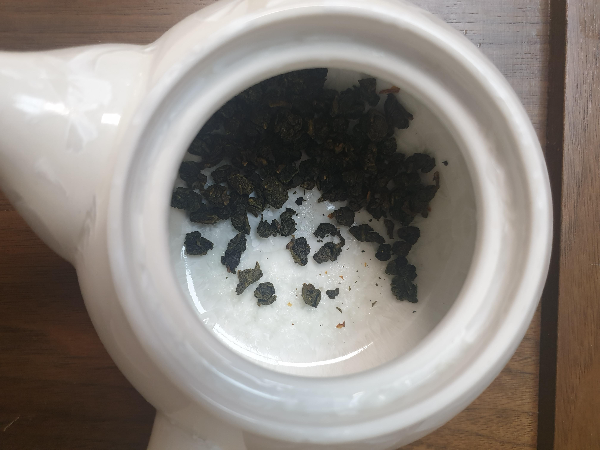 다완 안에 우롱차 잎이 넣어져 있다. 차는 동그랗게 뭉쳐져있다.