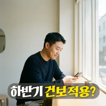 하반기 건보 적용?
20대 후반에서 30대 초반의 짧은 머리 한국인 남성이 밝은 창가 테이블에 앉아 안도하는 부드러운 미소로 스마트폰 뉴스를 확인하는 모습.
