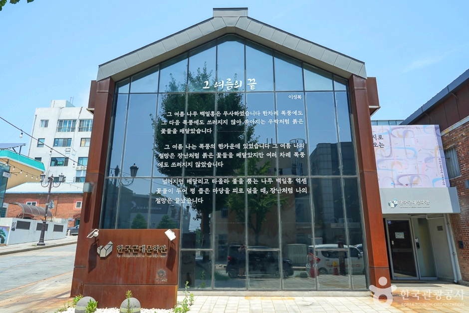 전면 유리창을 가진 건물로 유리창에 글이 쓰여져있다.
