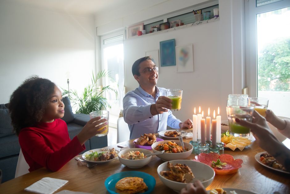 A joyful family lunch around a table with lighted candles and delicious dishes.