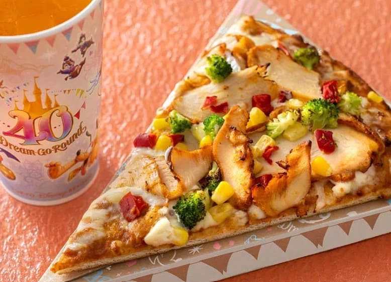 브로콜리 치킨 피망등 여러가지 토핑이 올라가 있는 피자 한 조각