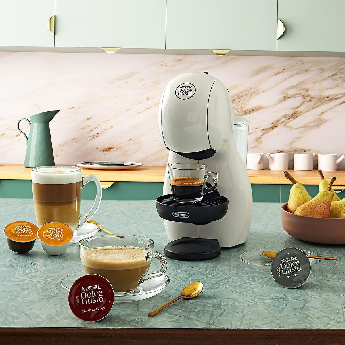 돌체 구스토 커피 머신과 다양한 커피 음료가 놓인 주방 테이블.
