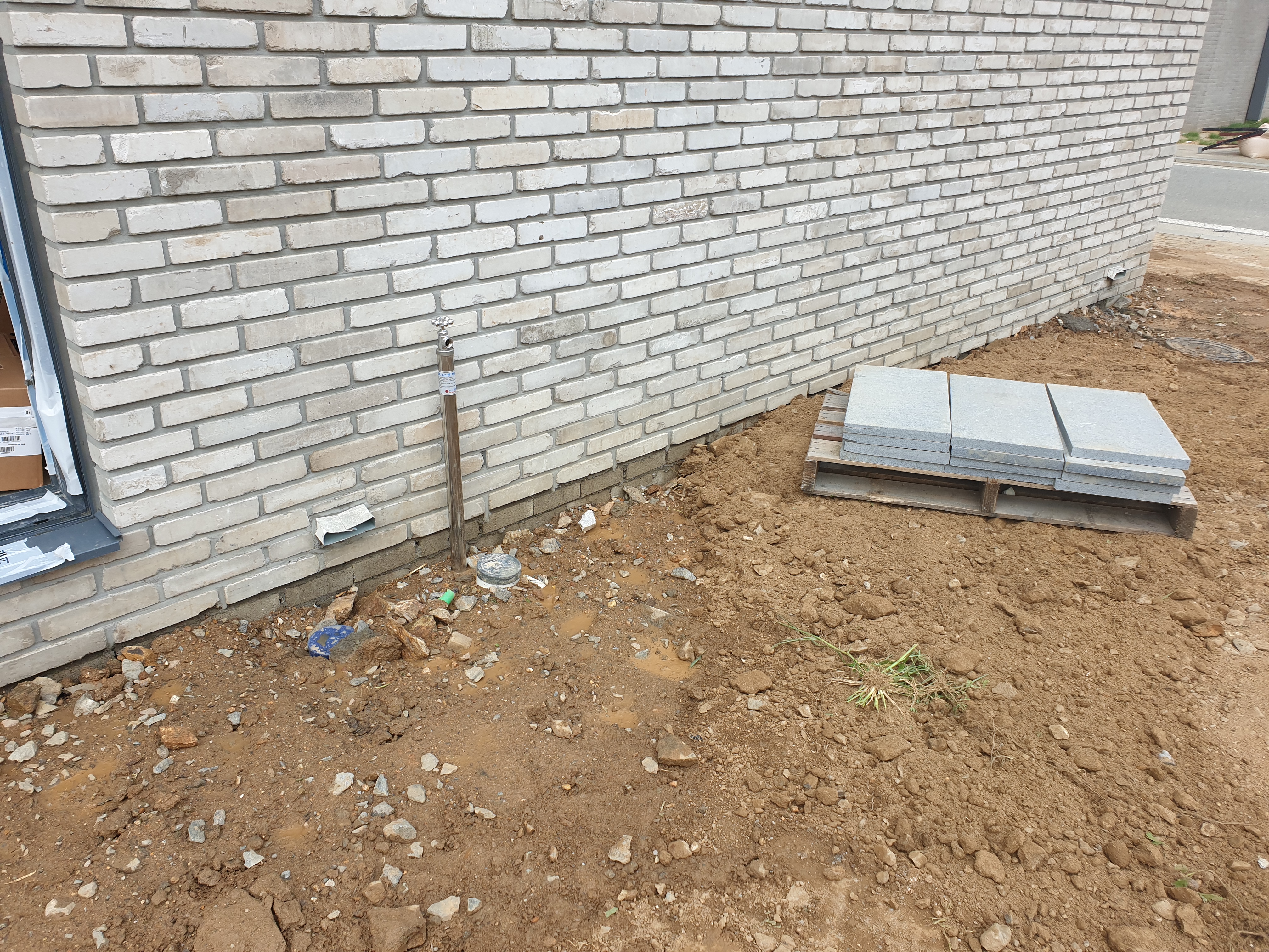 마당에 외부 수전을 설치하고 있는 모습