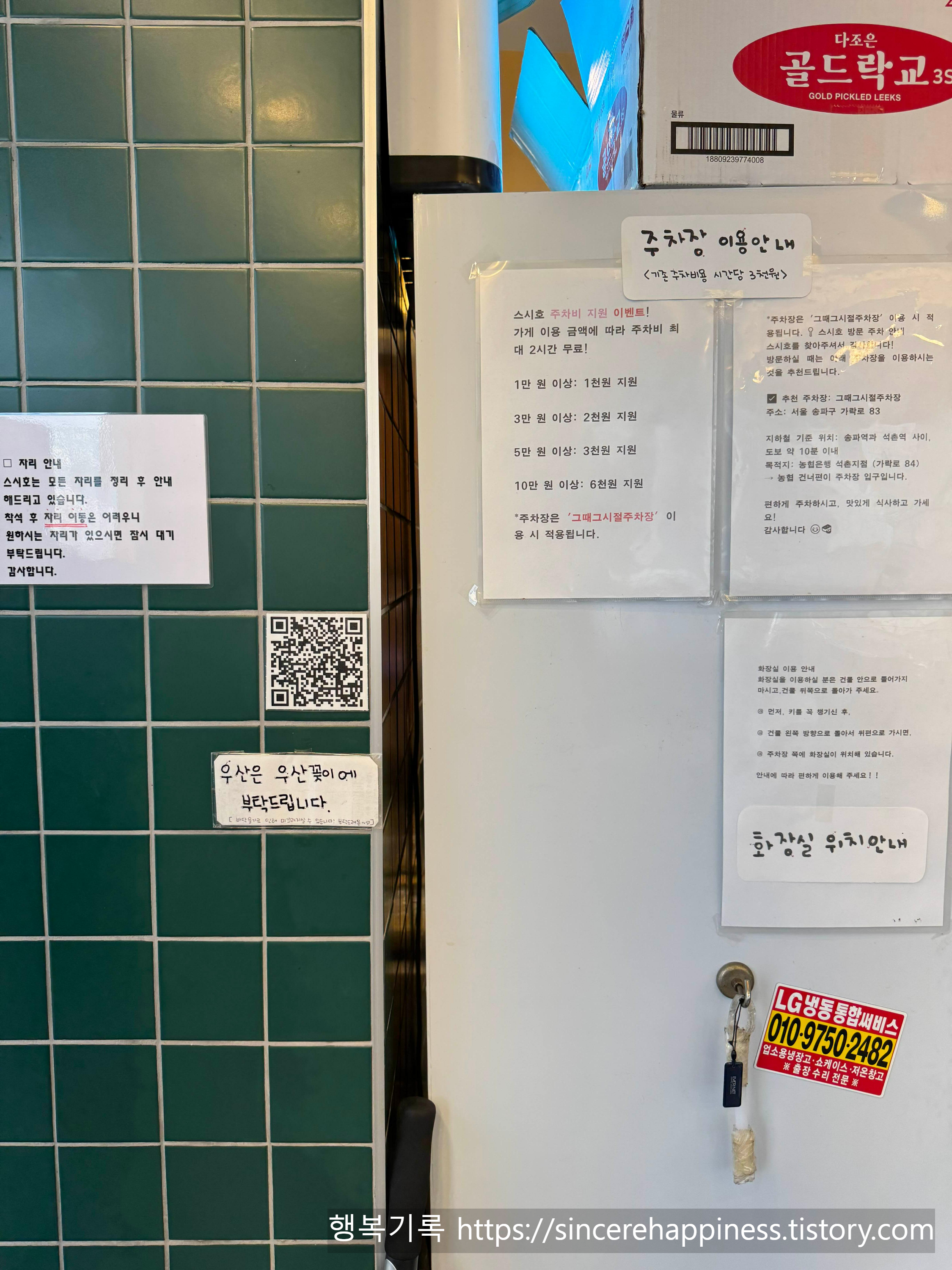 가게 벽면에 부착된 주차비 지원 안내문과 화장실 위치를 설명해 주는 안내문