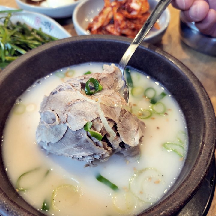 수육을 숫가락으로 들어 올림