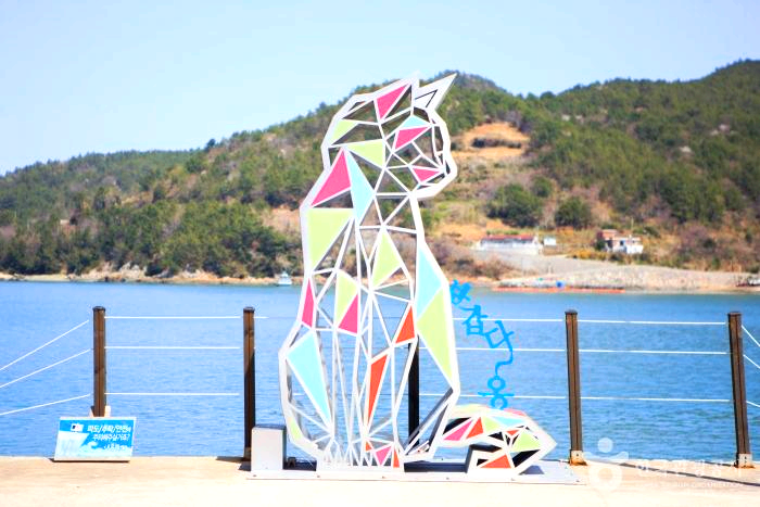 바다 앞에 고양이 모형이 있다.