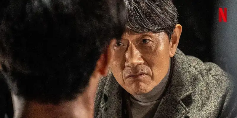 회색 겨울 코트를 입고 어느 누군가를 바라보고 있는 최 사장