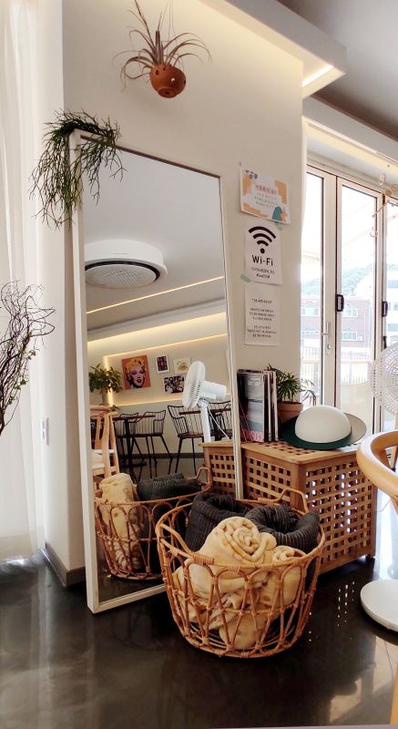 따스한 분위기가드는 인테리어 하얀거울과 나무로된 바구니에 담요가 놓여져있음