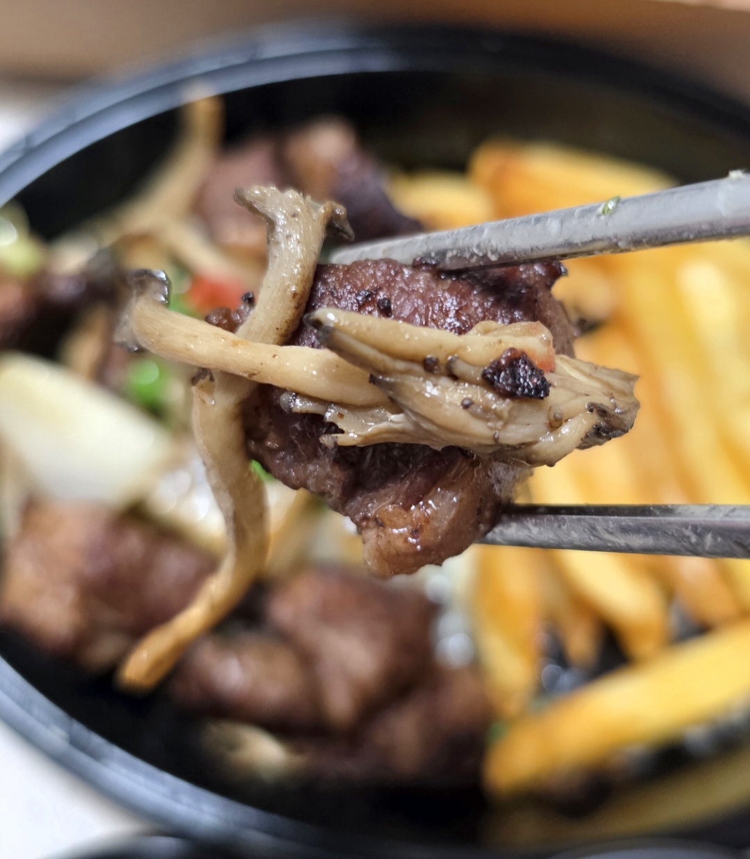 버섯과 함께 들어 올린 소갈비살 찹스테이크 고기