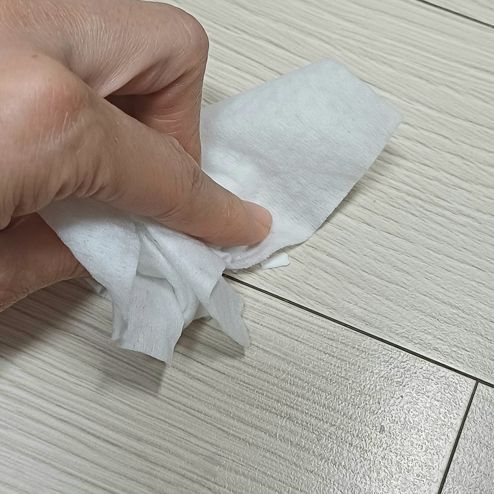 물티슈로 바닥에 남은 작은 도자기 조각을 정리하는 모습
