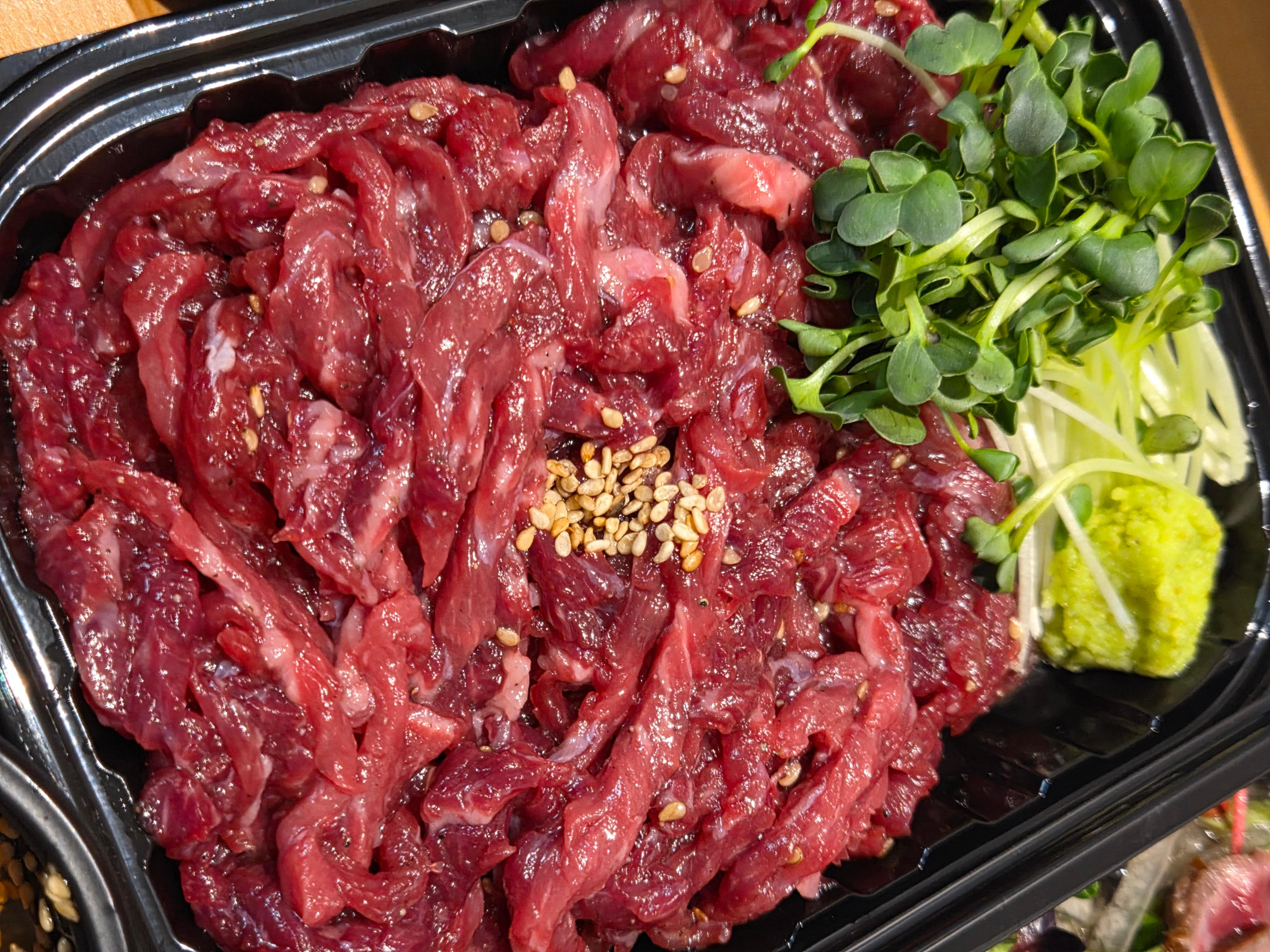 마곡 우화 한우육회 신선한 투플러스 한우 육회 위에 참깨가 올려진 모습 와사비와 어린잎도 함께 올려진 모습