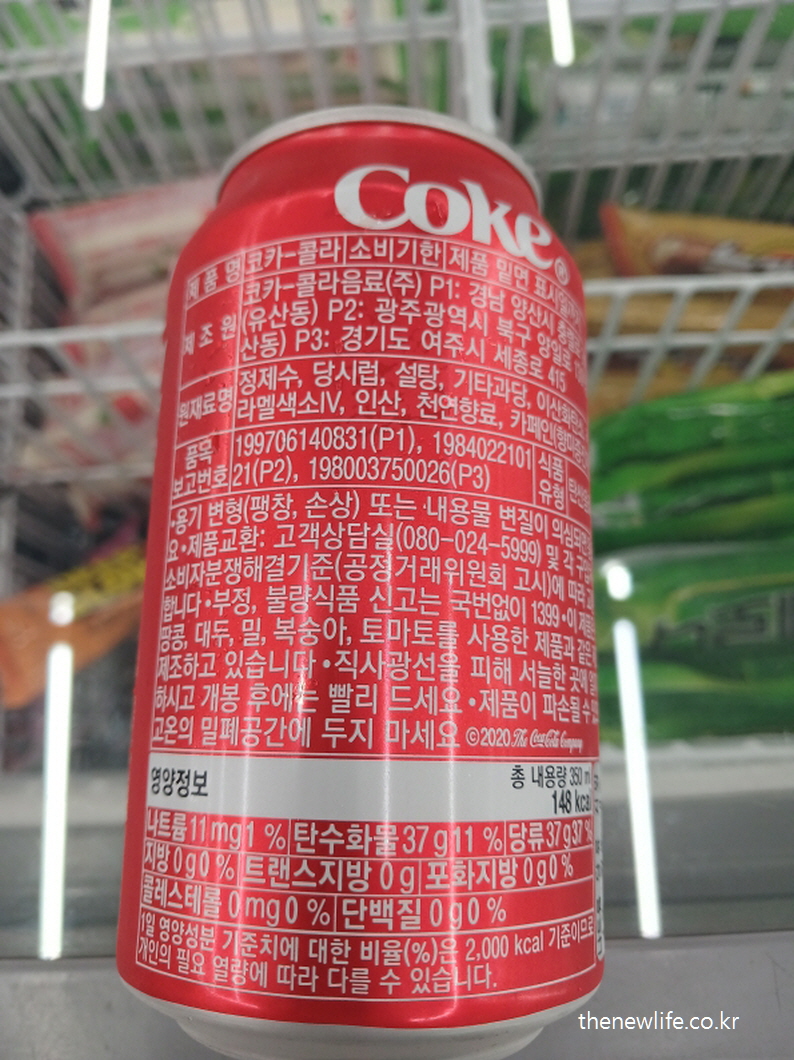 Nutrition label of a Coke can showing 37g sugar and 148kcal per serving.-콜라 한 캔의 영양성분표로, 당류 37g과 총 148kcal가 포함되어 있다.