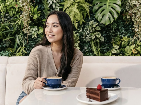 뒷면 플렌테리어로 인테리어가 된 카페에서 커피를 마시는 손님