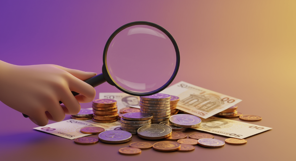확대경으로 환급금을 찾아보는 사람이 쌓여 있는 동전과 지폐를 들여다보는 모습.