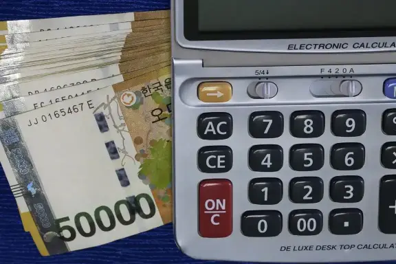 뭉쳐져 있는 5만원들 위 계산기