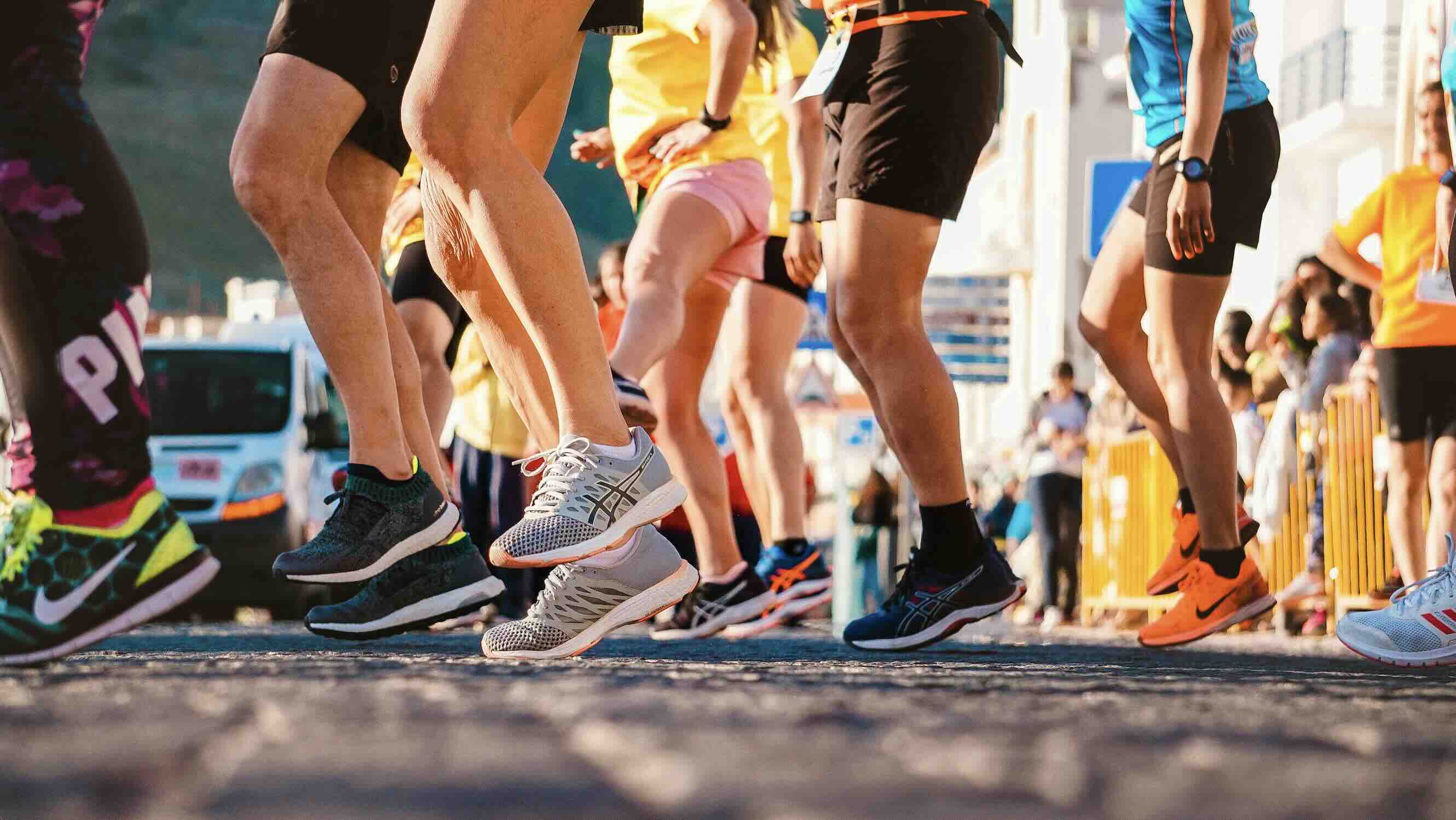 러닝화를 신은 사람들의 발을 클로즈업 한 사진