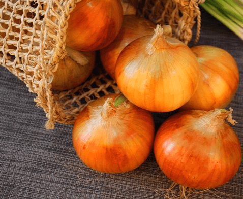 연갈색 껍질을 가진 둥그런 양파들이 그물 가방에서 쏟아져 나온다.