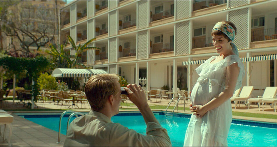 호텔을 배경으로 임신한 소냐의 사진을 찍어주고 있는 젊은 오베