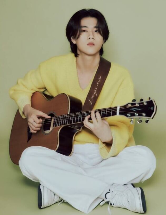 가수-이무진이-통기타를-들고-앉아-포즈를-취하고-있는-사진