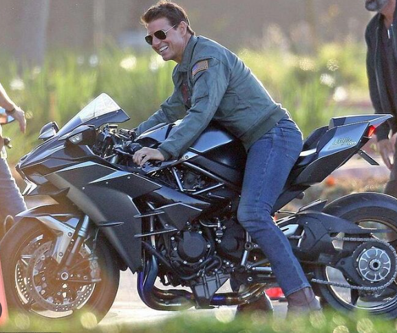 탑건 매드릭은 오토바이를 탔고 의상은 자켓을 입었으며 선그라스 꼈다.